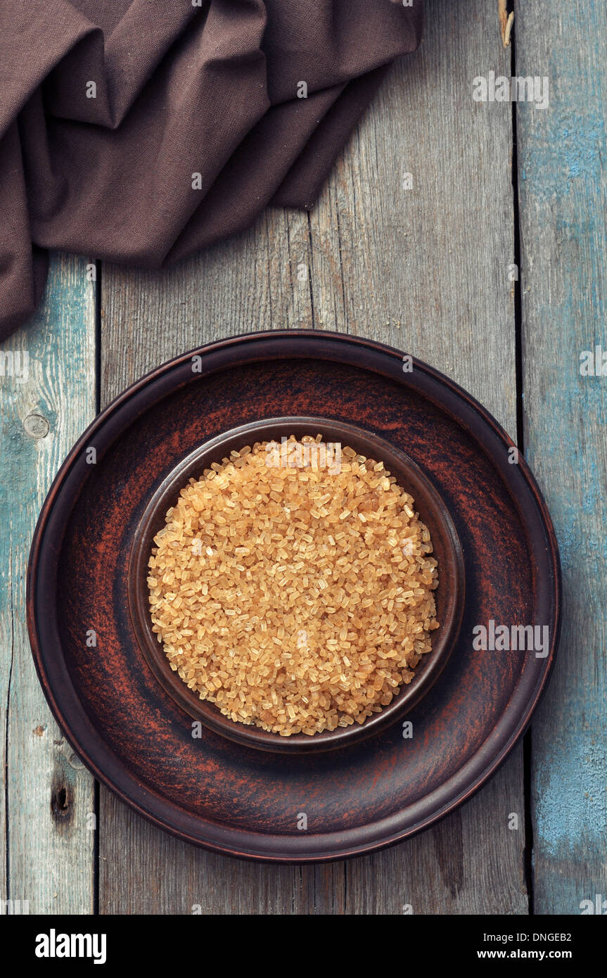 Brown candy sugar on brown plate. Top view. Stock Photo