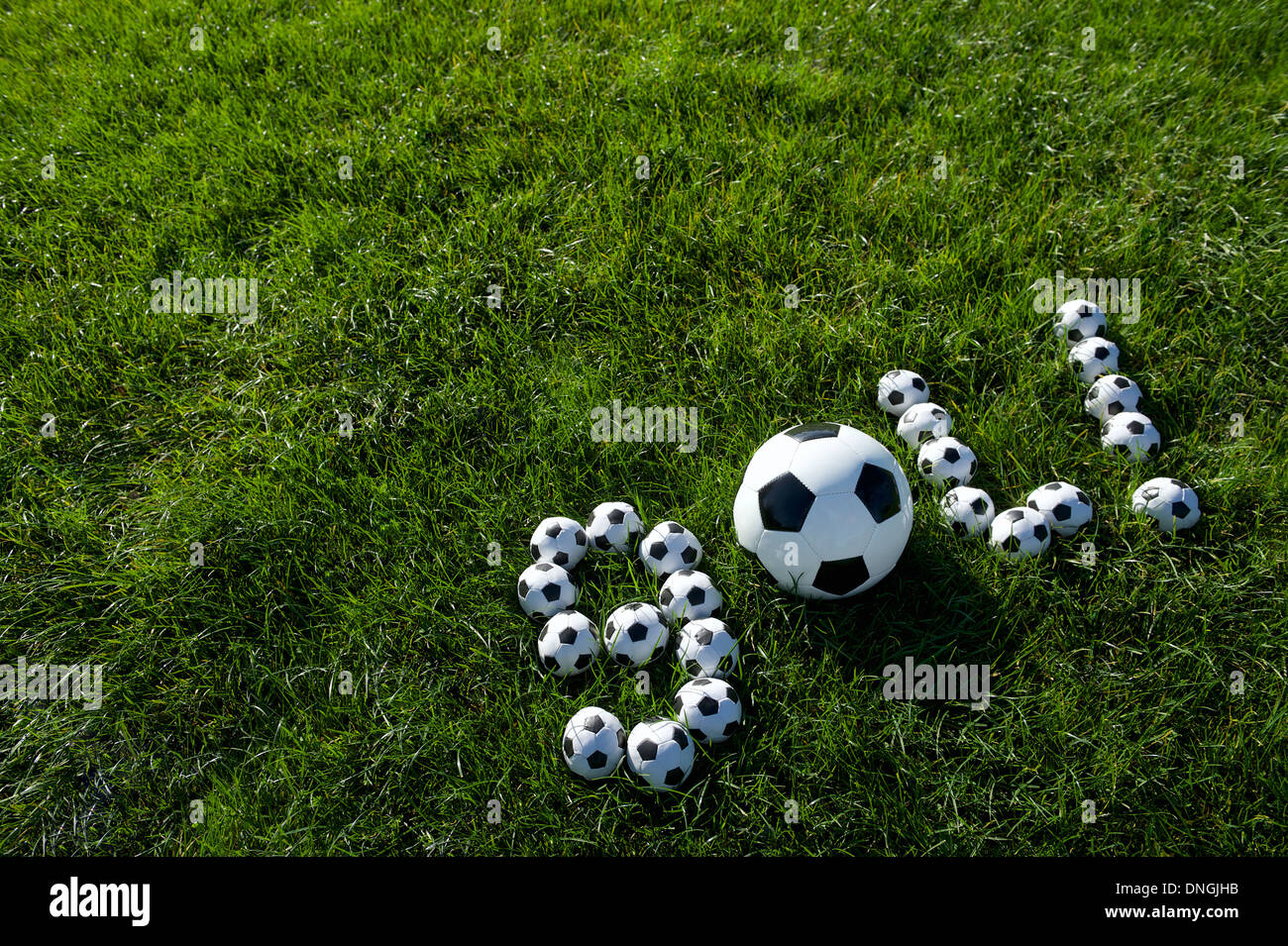 Brazilian soccer goal message spells out gol in footballs on green grass field Stock Photo