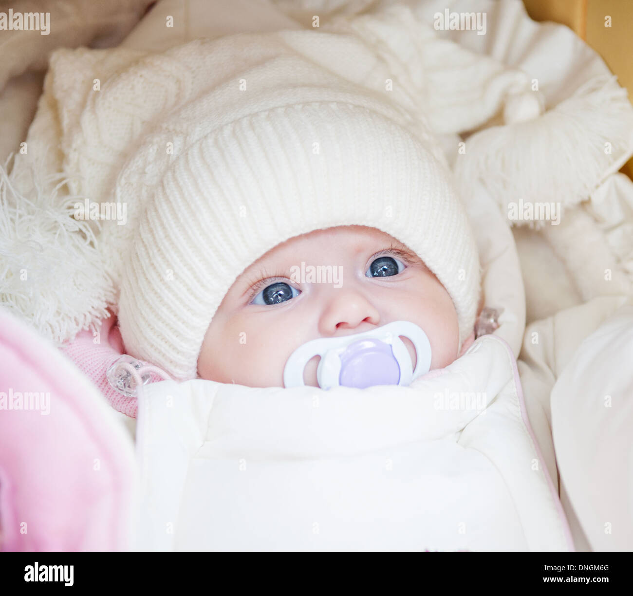 Adorable baby girl wearing white winter hat Stock Photo