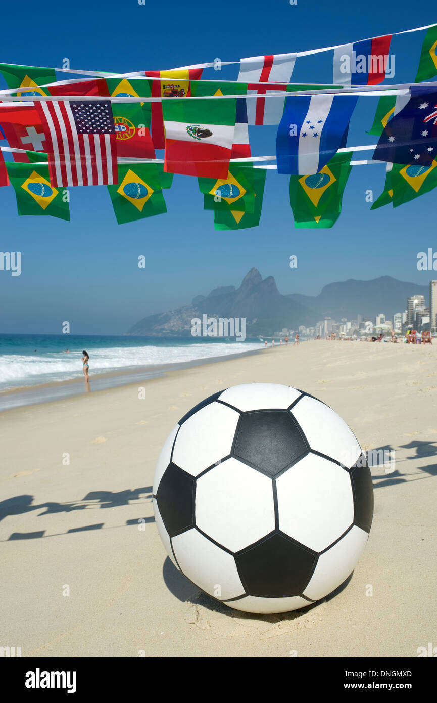 Soccer ball football on the beach in Rio de Janeiro under international flag bunting Stock Photo