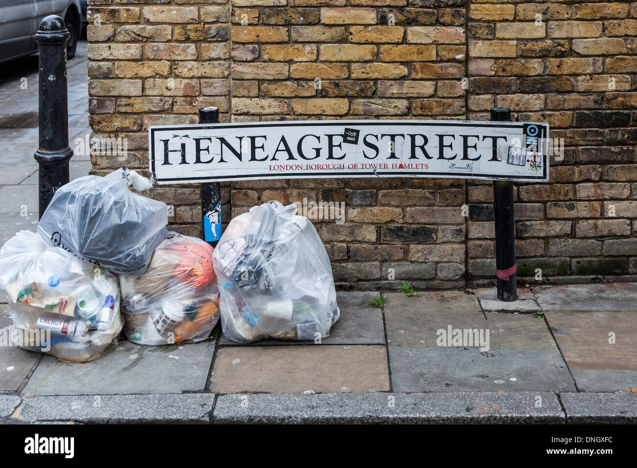 Heneage street sign and garbage bags Spitalfields, Tower Hamlets