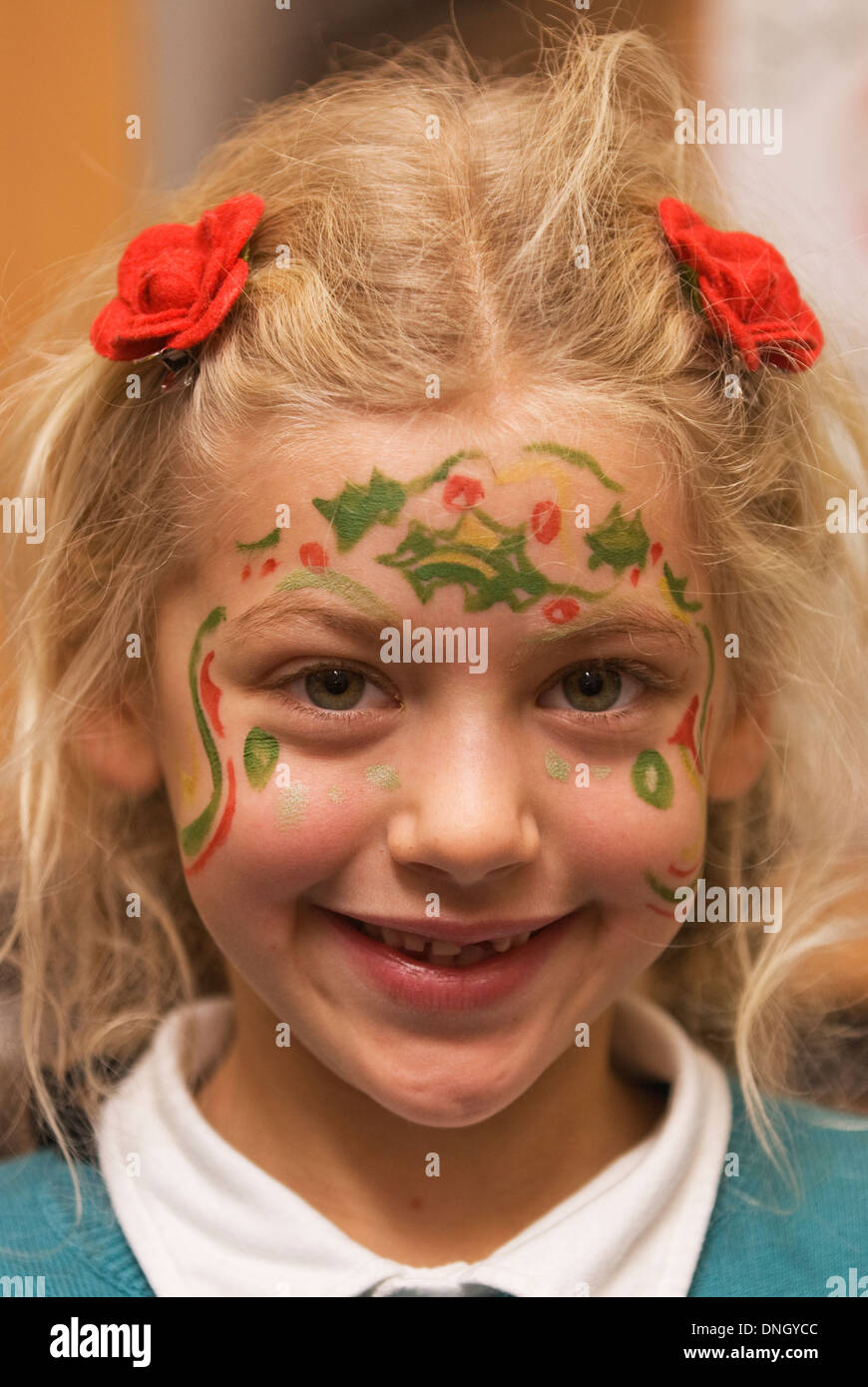 7 year old girl with her face painted for christmas at a school xmas fayre, Steep, near Petersfield, Hampshire, UK. Stock Photo