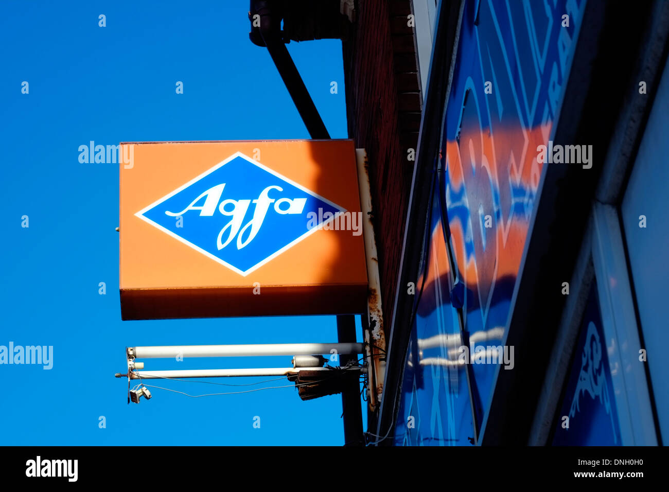 old neon sign hanging from shop frontage with the blue and orange agfa symbol Stock Photo