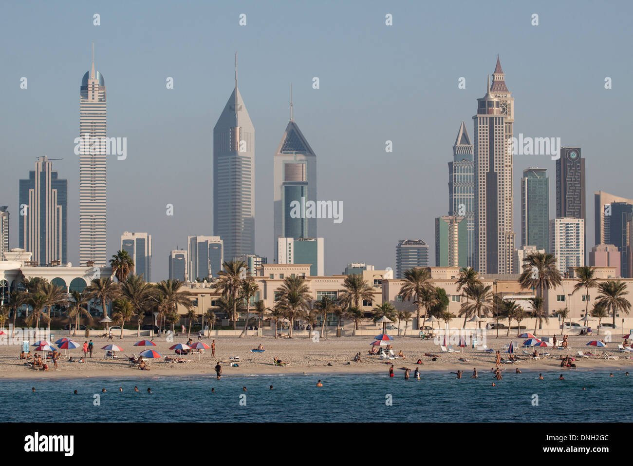 SETTING SUN OVER THE BEACH AND THE SKYLINE OF SHEIKH ZAYED ROAD, DUBAI, UNITED ARAB EMIRATES, MIDDLE EAST Stock Photo