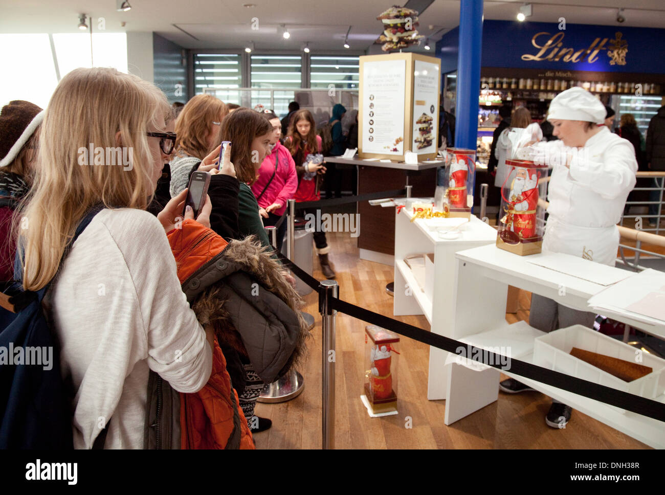 Cologne chocolate museum - visitors watching a Lindt employee packing a chocolate Santa Clause, Cologne Germany Europe Stock Photo