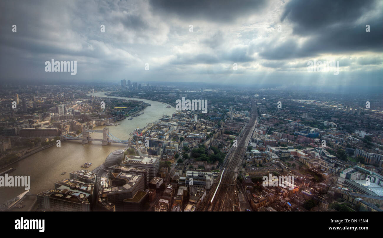 City of London from the Shard. Tower bridge on the River Thames leading to Canary Wharf in a cloudy day. Stock Photo