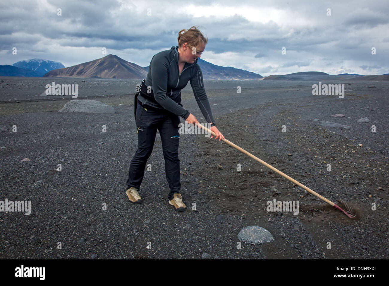 YOUNG WOMAN RESTORING F 910 WORN BY 4X4 VEHICLES, TRAIL LEADING TO THE VOLCANO ASKJA AND THE KVERKFJOLL MOUNTAIN, VOLCANIC DESERT AND LAVA FIELD, HIGHLANDS OF ICELAND, NORDURLAND EYSTRA, EASTERN CENTRE OF ICELAND, EUROPE Stock Photo