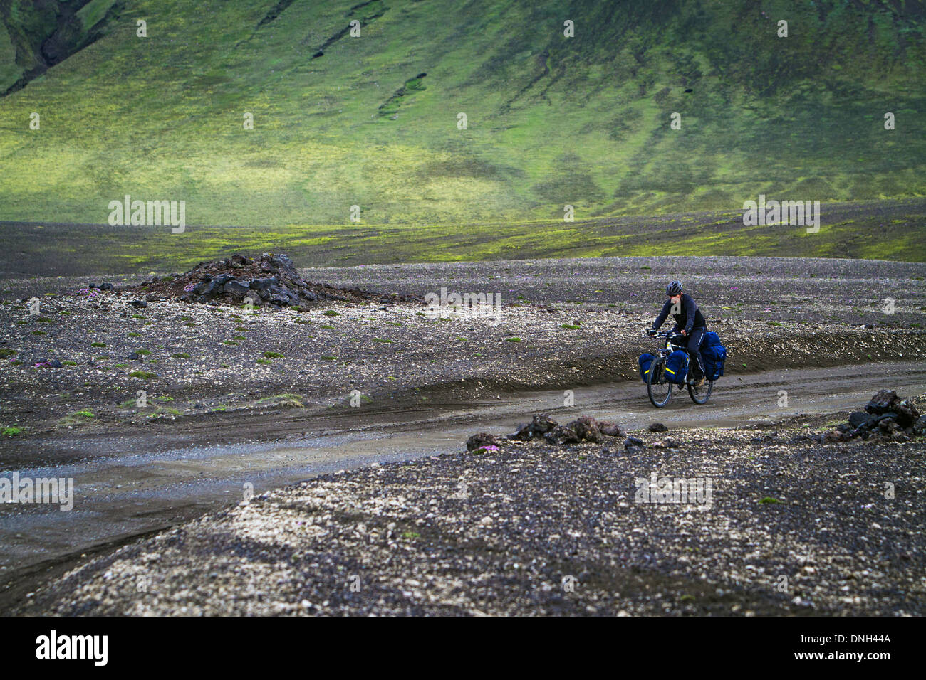 CYCLING ON THE TRAILS IN LANDMANNALAUGAR, VOLCANIC AND GEOTHERMAL ZONE OF WHICH THE NAME LITERALLY MEANS 'HOT BATHS OF THE PEOPLE OF THE LAND', REGION OF THE HIGH PLATEAUS, SOUTHERN ICELAND, EUROPE Stock Photo