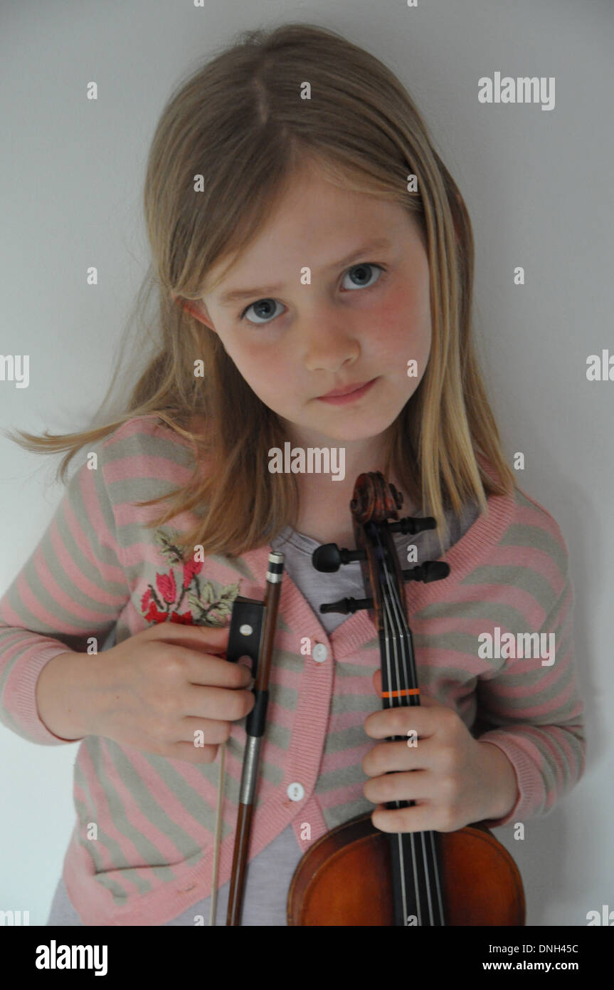 little blonde girl holds her violin and bow Stock Photo