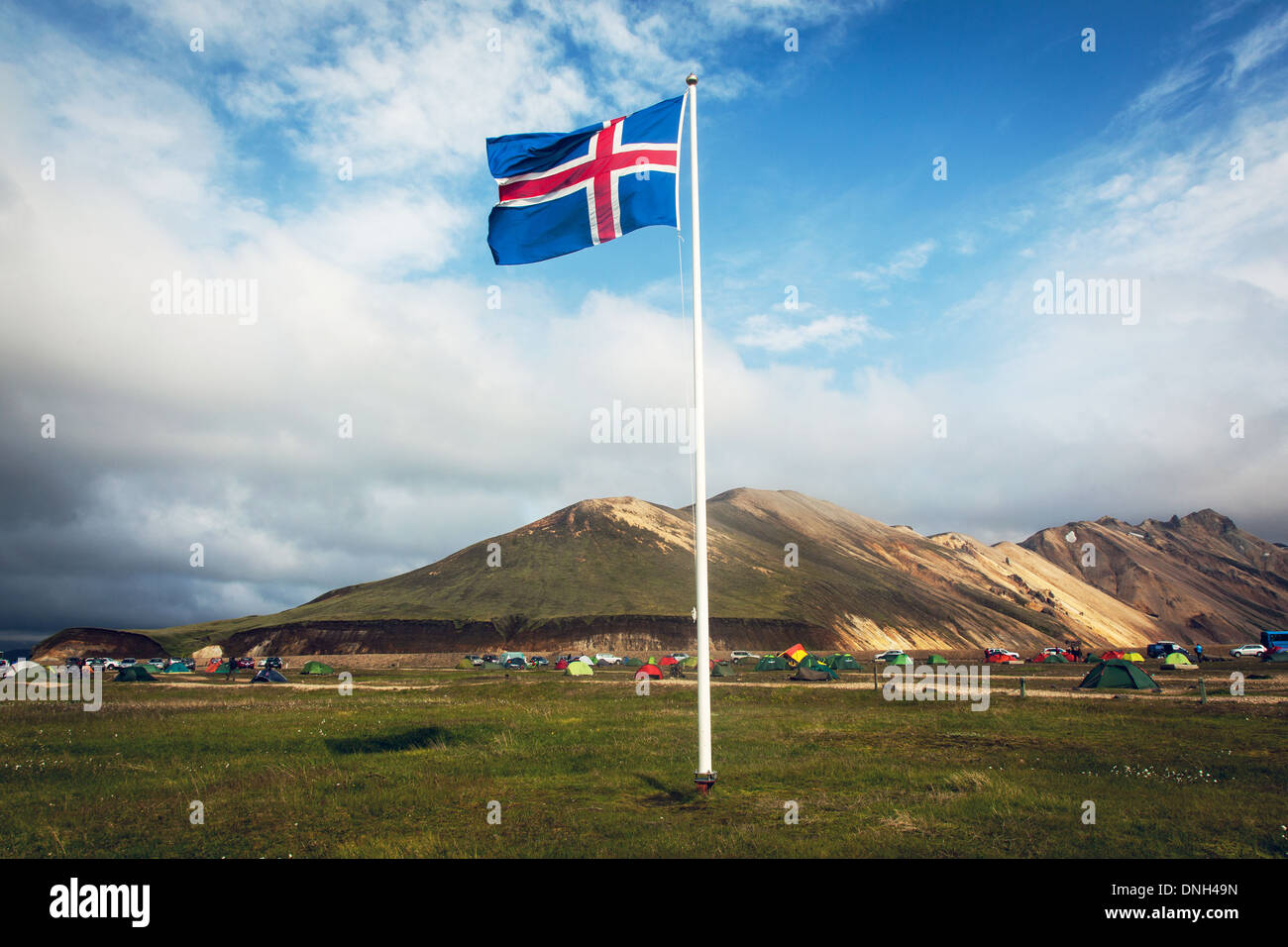 ICELANDIC FLAG WAVING OVER THE CAMPSITE OF LANDMANNALAUGAR, VOLCANIC AND GEOTHERMAL ZONE OF WHICH THE NAME LITERALLY MEANS 'HOT BATHS OF THE PEOPLE OF THE LAND', REGION OF THE HIGH PLATEAUS, SOUTHERN ICELAND, EUROPE Stock Photo