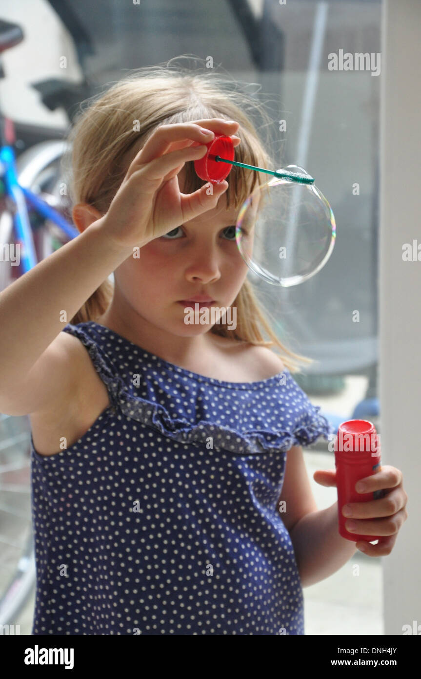 little girl blows bubbles Stock Photo