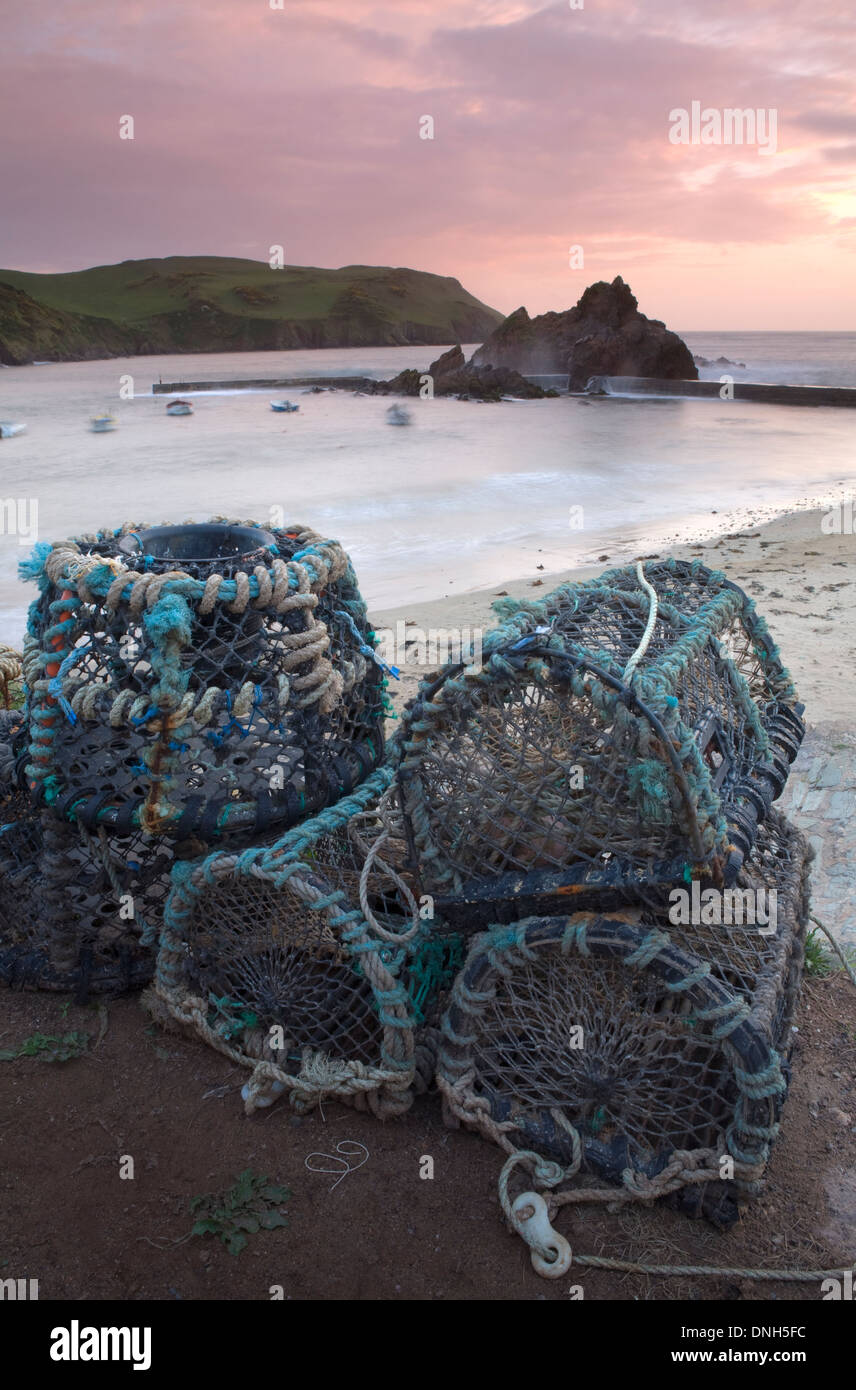Lobster pots stacked up at the harbour in Hope Cove, Devon, England, at