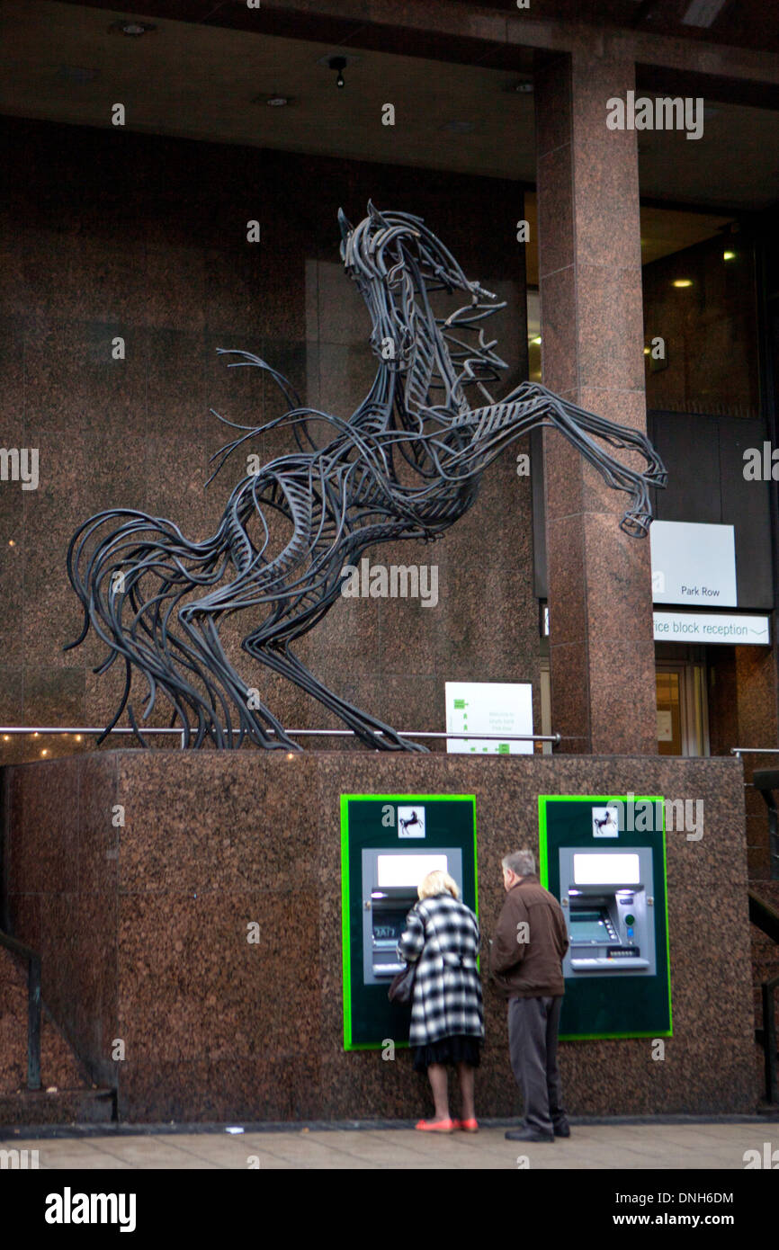 Senior citizens drawing cash from a Lloyds Bank ATM machine in Leeds City Centre Stock Photo
