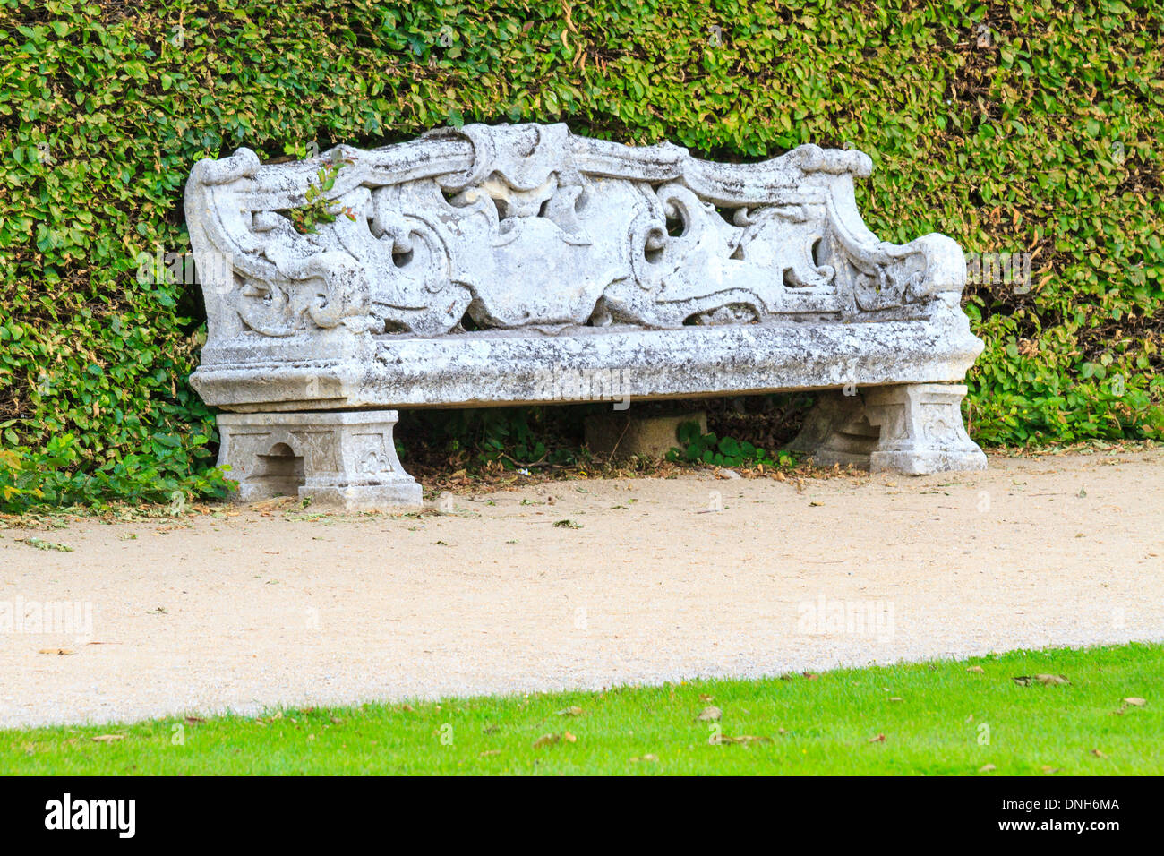 Ornamental English garden with stone bench Stock Photo