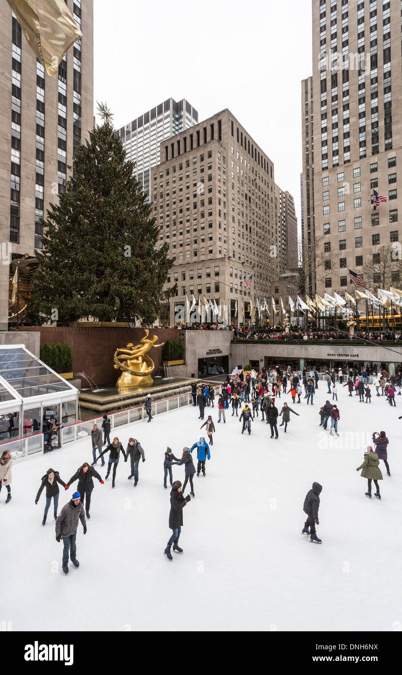 Ice skaters enjoying skating on the ice rink at The Concourse at the Rockefeller Center, New York, USA with Xmas tree in winter Stock Photo