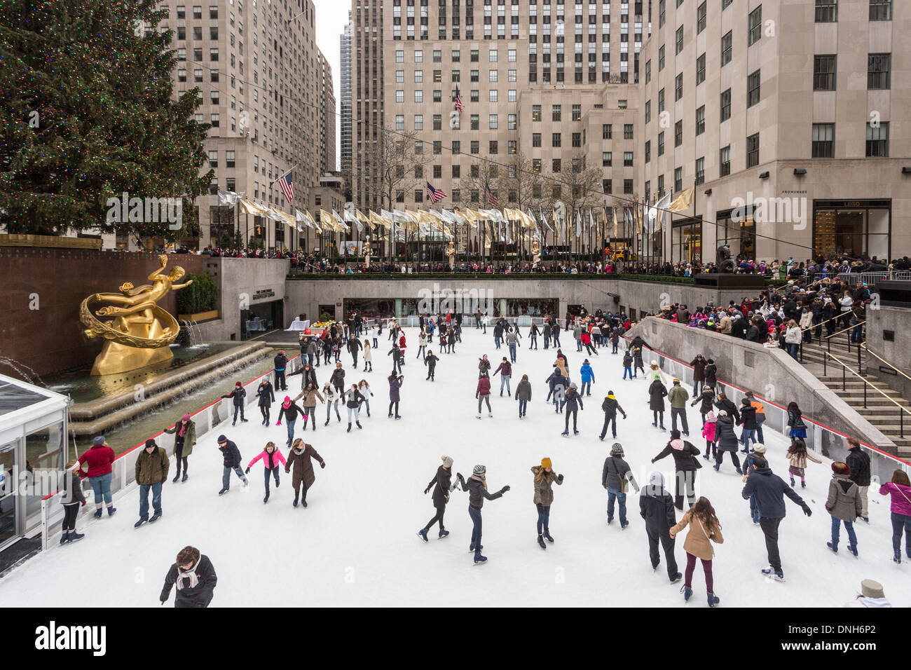 A crowd of ice skaters enjoying skating on the ice rink at The Concourse at the Rockefeller Center, New York, USA in winter Stock Photo