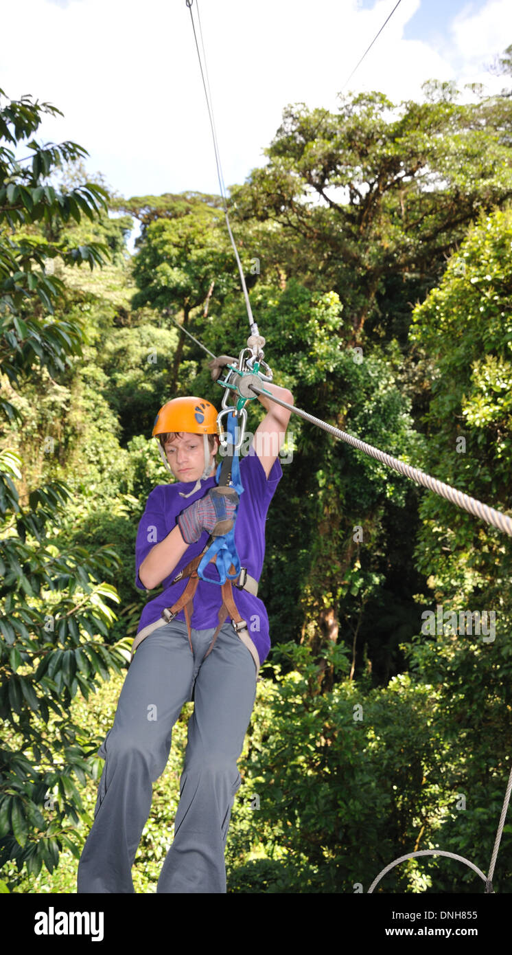 Teenage Boy Zip lines in Monteverde cloud forest Costa Rica Stock Photo