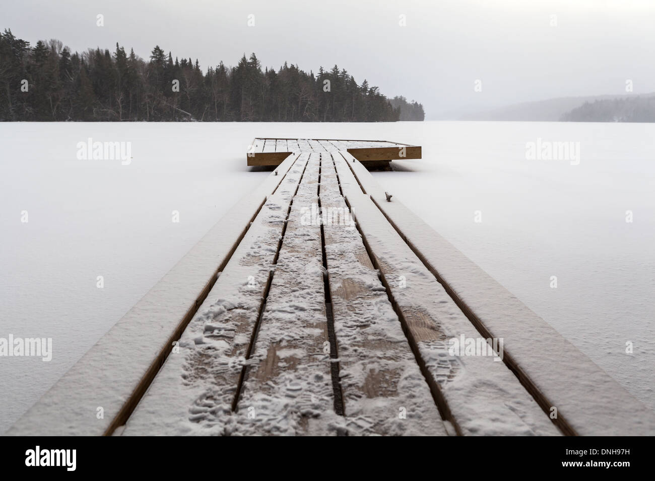 Wooden pier on the frozen lake Stock Photo