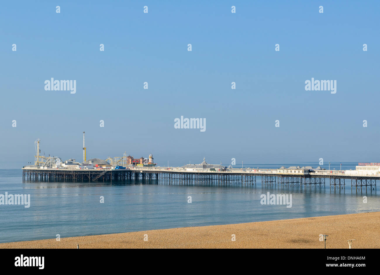 English seaside pier, calm reflective sea, blue sky and empty beach Stock Photo
