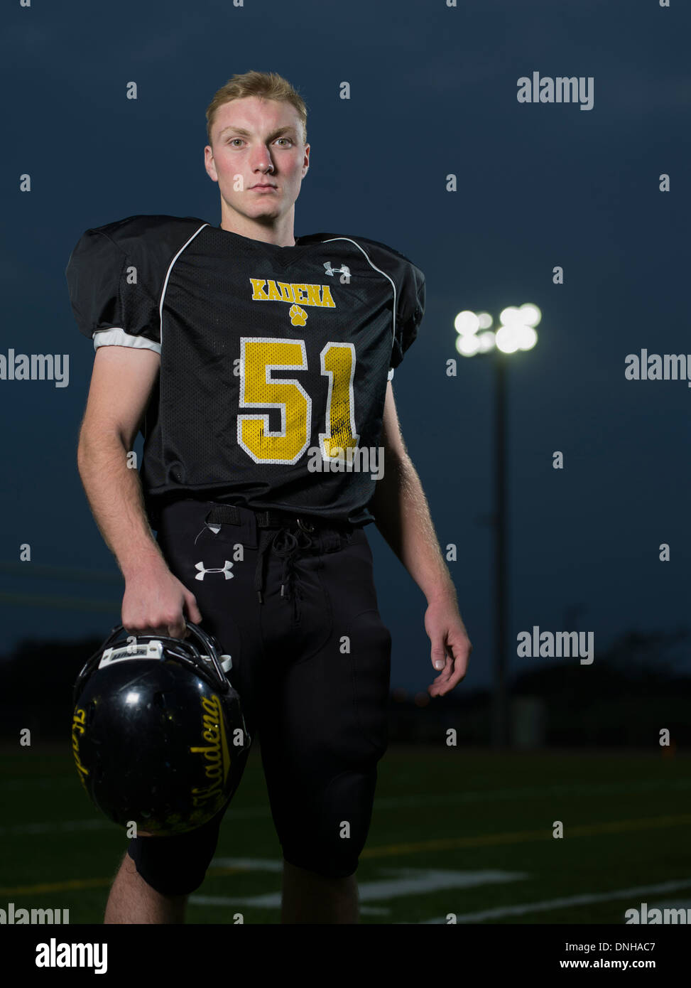 American High School Football Player in uniform with helmet and football. Stock Photo