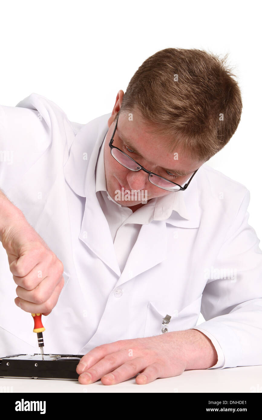 a man with a screwdriver disassembles a computer hard drive repair Stock Photo