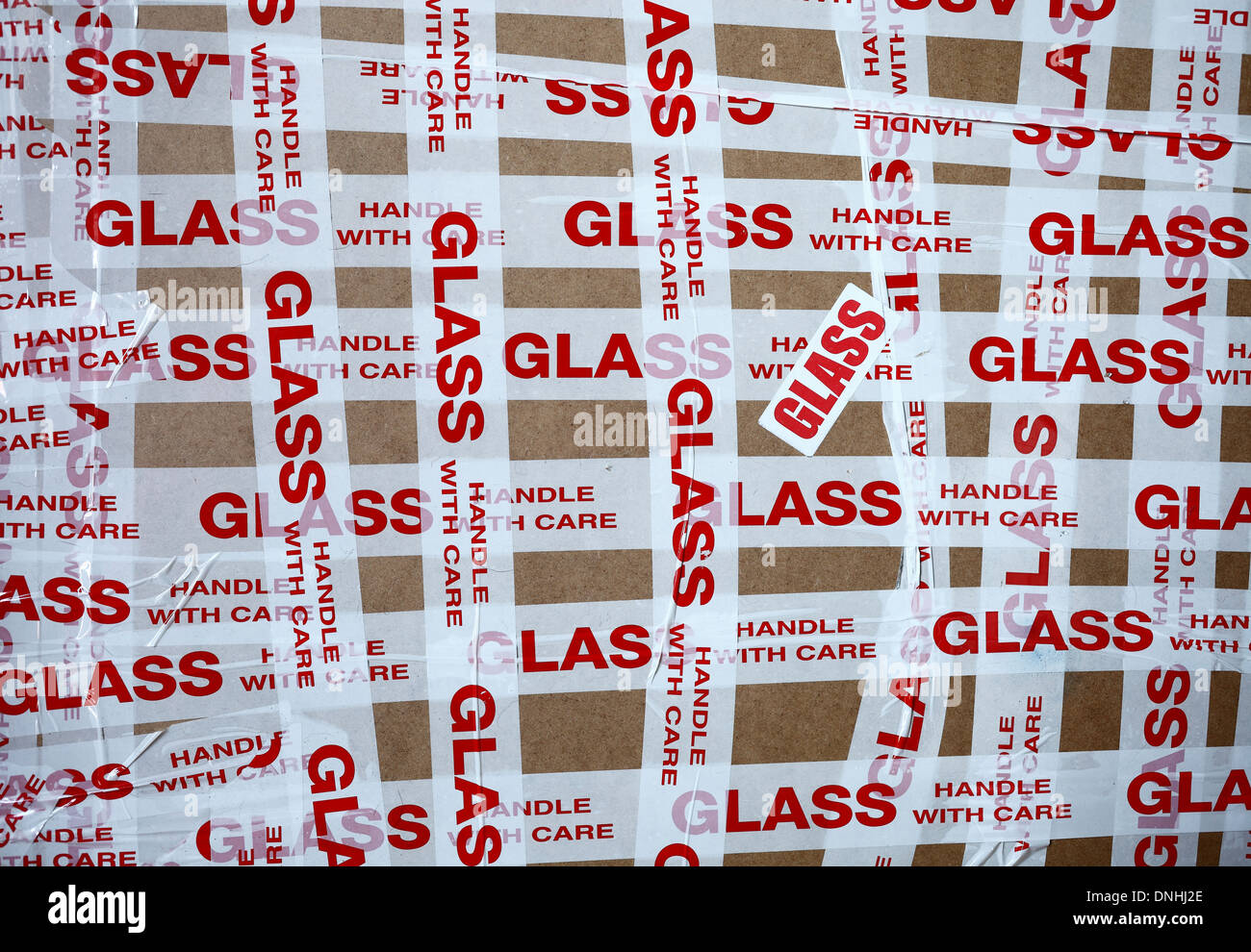 'Glass Handle with Care' tape wrapped around a fragile parcel. Stock Photo