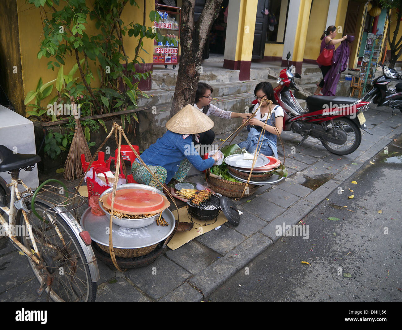 Family preparing meal in street in Hoi Ann, Vietnam Stock Photo