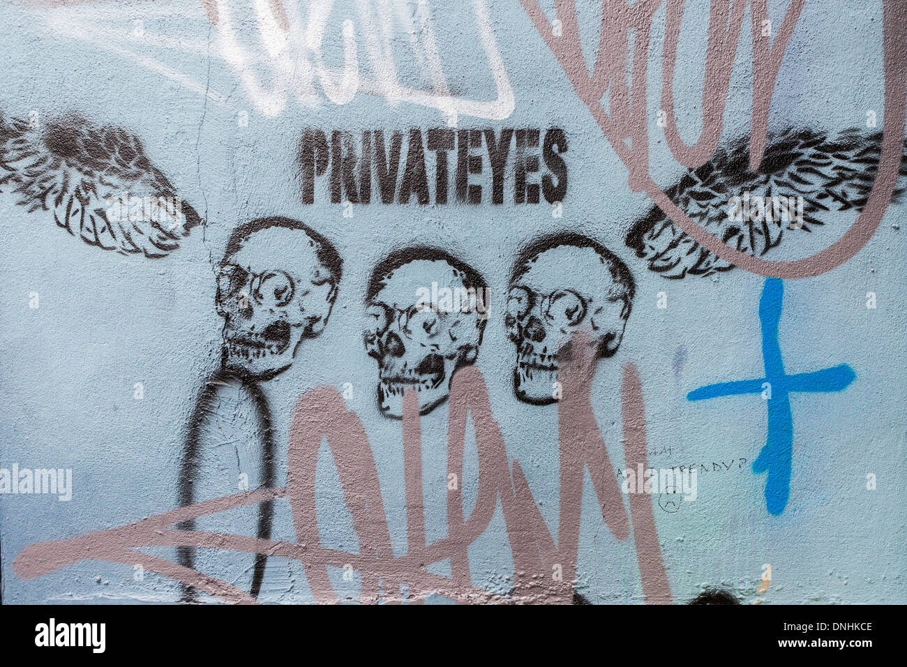 Street stencil art 'Private Eyes' - Three skulls and wings Heneage street - Brick lane, East London, UK Stock Photo