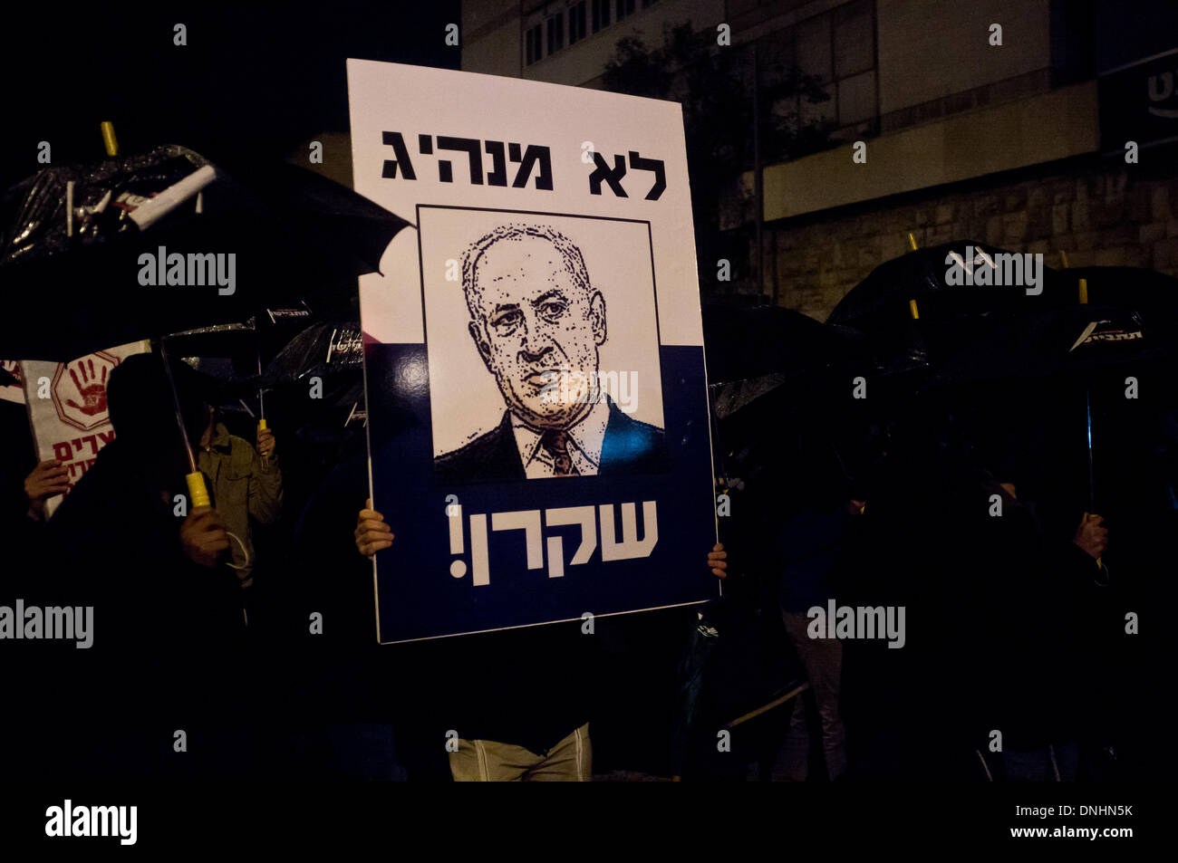 Jerusalem, Israel. 30th Dec, 2013. Protesters carry a placard depicting PM Netanyahu which reads; 'Not a leader. A liar.' as they protest government intention to release convicted terrorists in the framework of peace negotiations with the Palestinians. Jerusalem, Israel. 30-Dec-2013.  Almagor Terror Victims Association leads a 'Black Umbrellas March' protesting planned Palestinian prisoners release later tonight, pointing to Chamberlain's appeasement policies and misjudgments that nearly caused Britain's WWII defeat. Credit:  Nir Alon/Alamy Live News Stock Photo