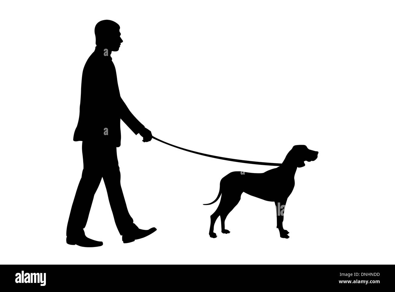 silhouette of a man walking a dog Stock Photo