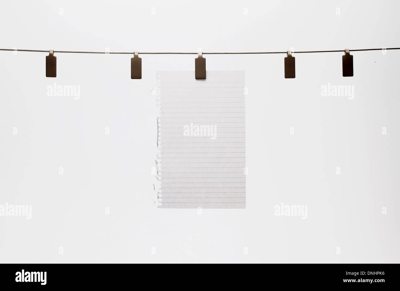 A blank piece of paper hanging with a clip to a straight wire. White background Stock Photo