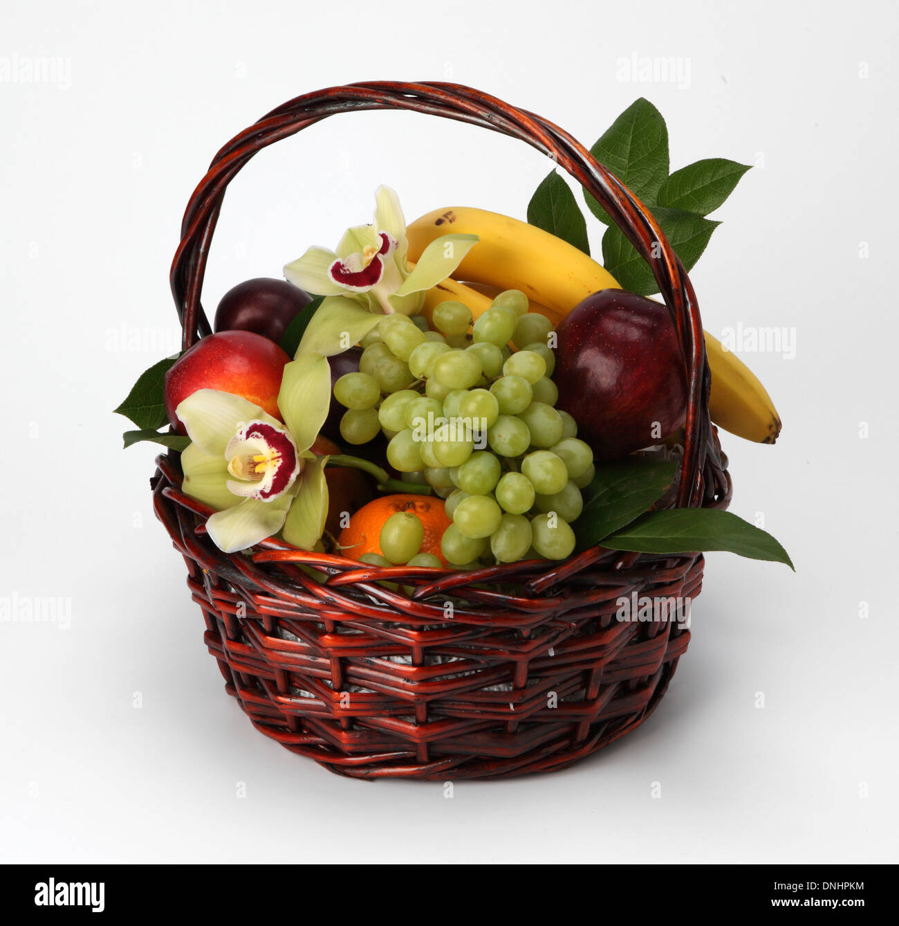 A basket filled with assorted fruit on a white background Stock Photo