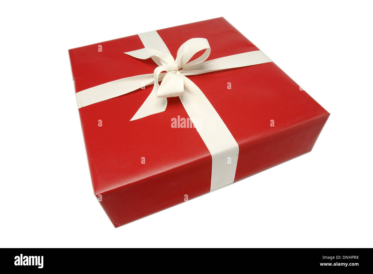 A wrapped present with red paper and a ribbon bow on a white background. Stock Photo