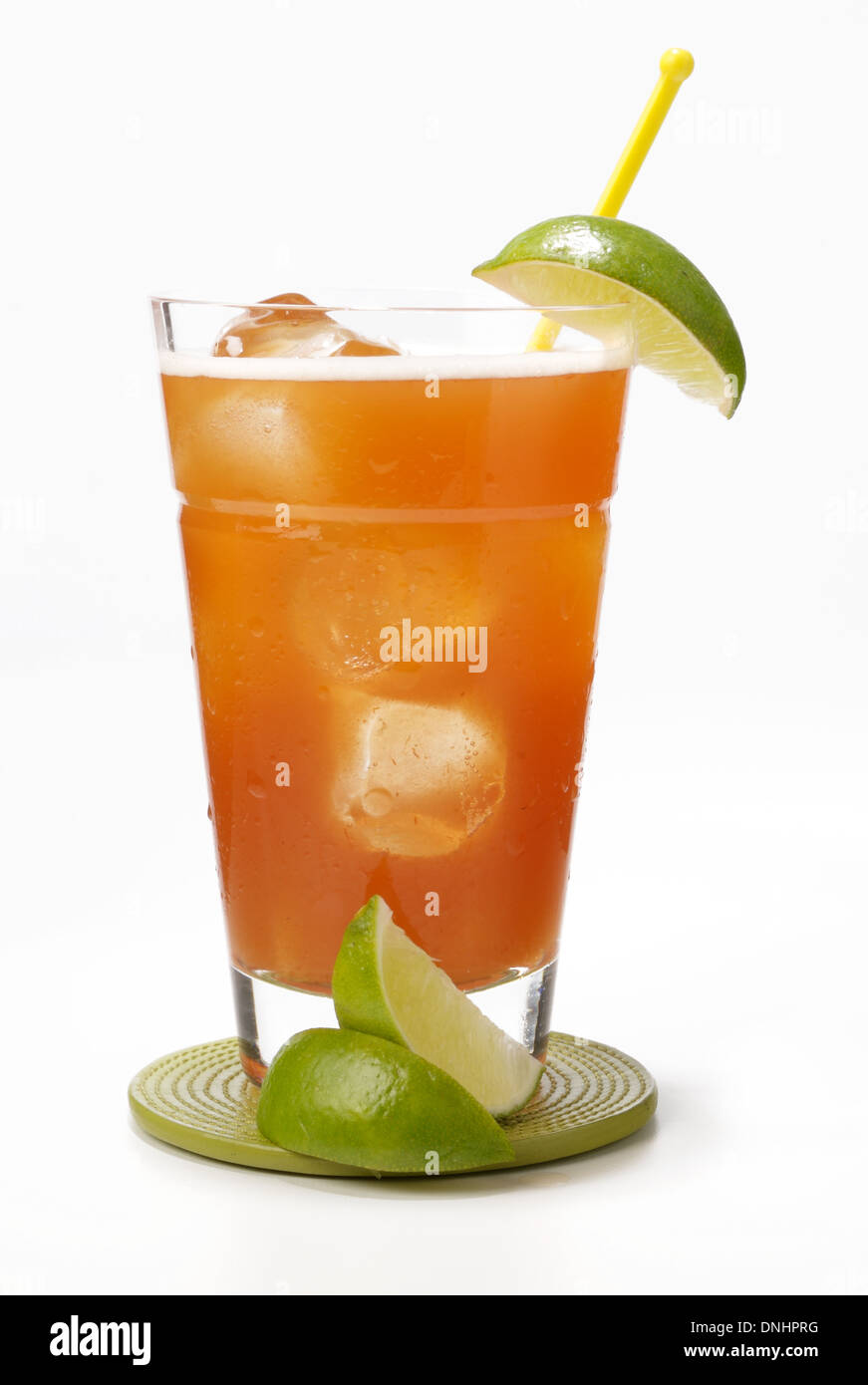 A orange cocktail drink in a glass with a green lime wedges as garnish. Stock Photo