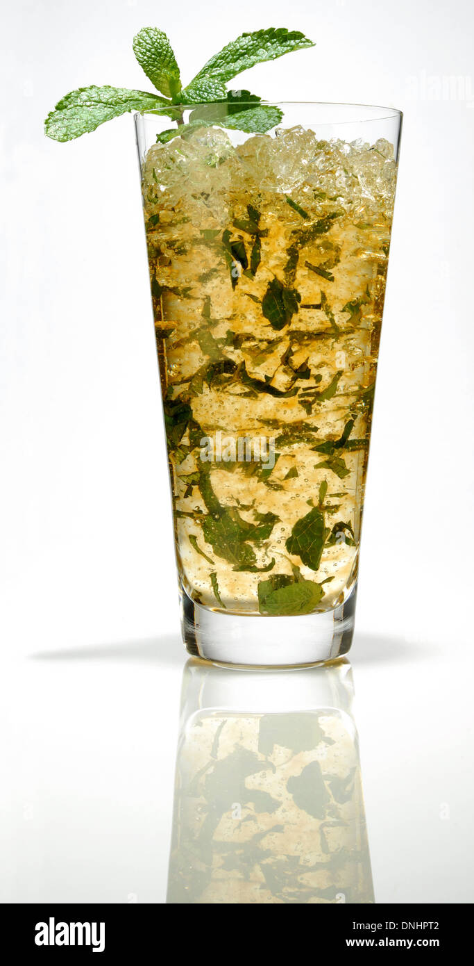 A colorful iced cocktail drink in a glass with a mint leaf garnish. Stock Photo