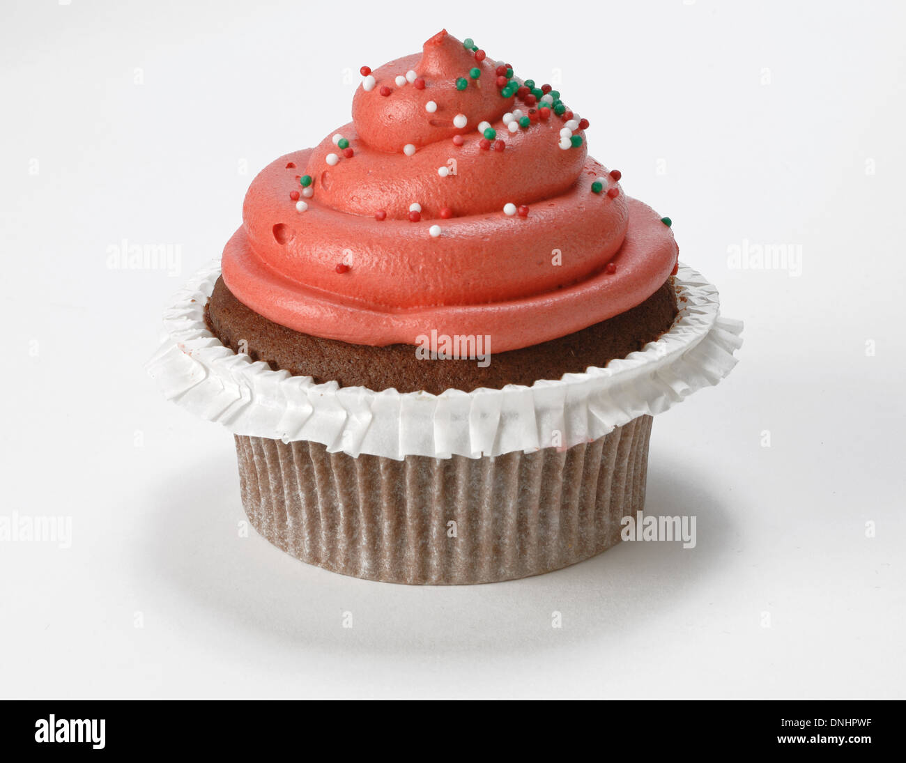 A single decorated red cupcake on a white background. Stock Photo