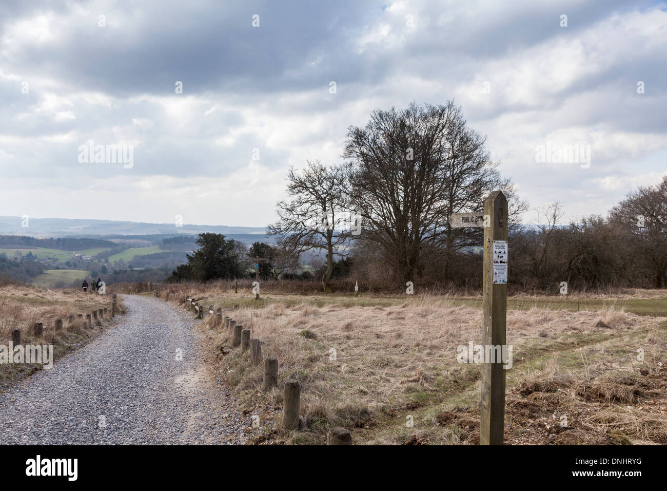 Winter Surrey countryside panorama: footpath with wooden public byway fingerpost and walkers, Newlands Corner near Guildford, UK Stock Photo