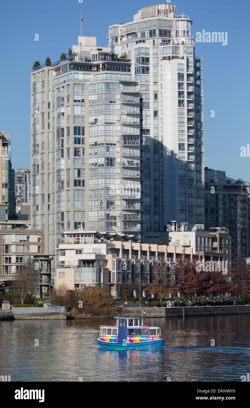 Granville Island ferry, seen from False Creek with tall buildings in the background. Stock Photo