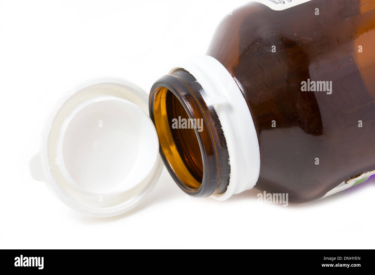 Empty medicine bottle with open cap on white background. Stock Photo