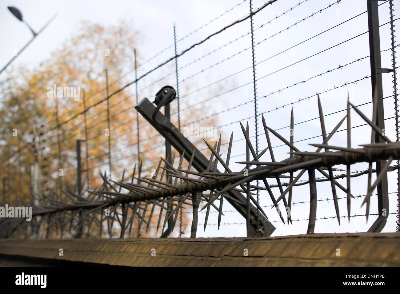 Security perimeter fence with sharp spikes and barbed wire on the top
