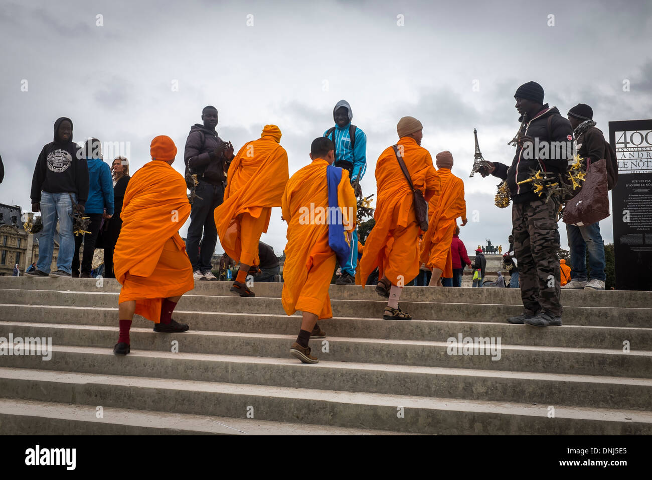 buddhist monks encounter street traders near the Louvre museum Paris France. Stock Photo