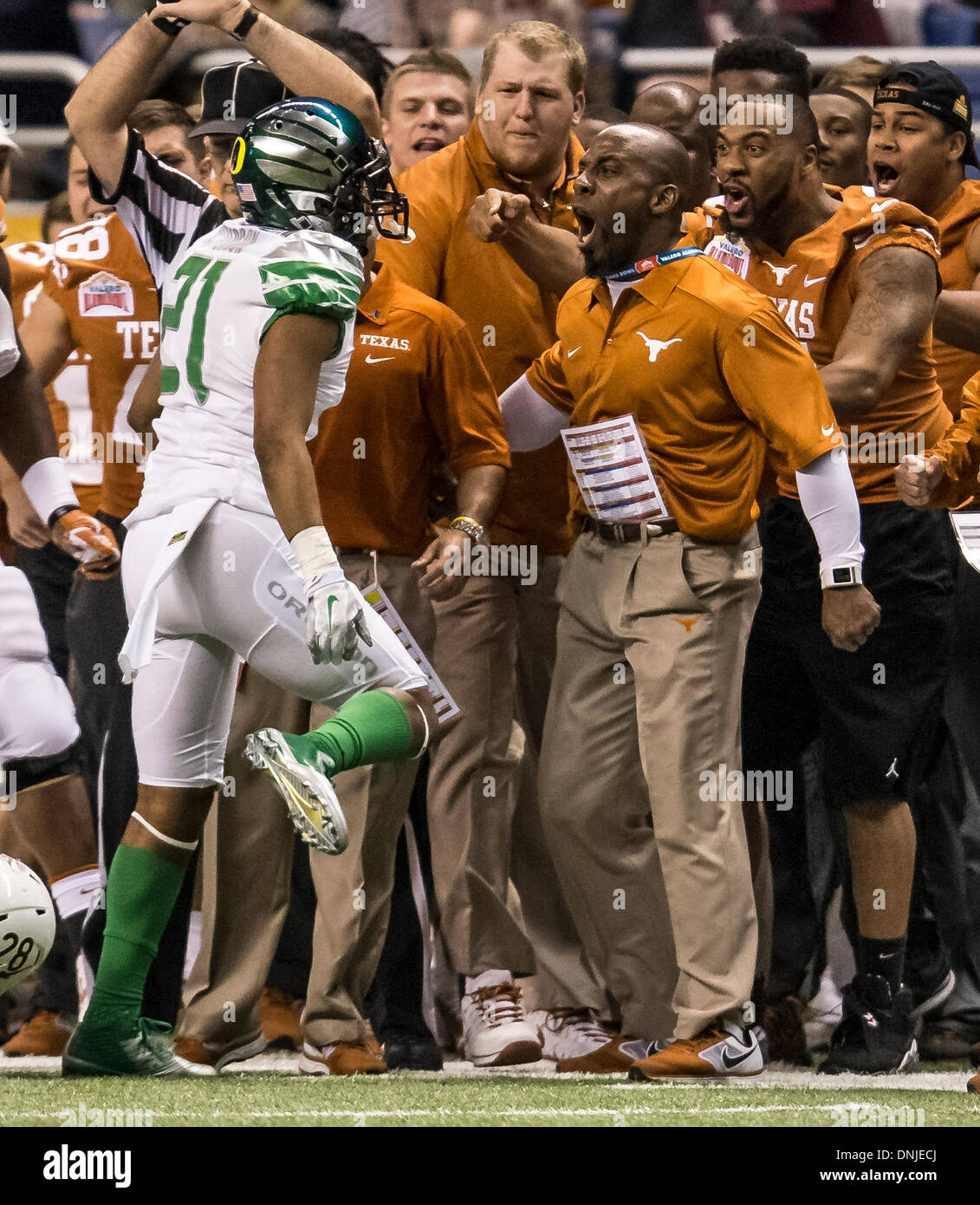 San Antonio, Texas, USA. 30th Dec, 2013. December 30, 2103: Oregon Ducks cornerback Avery Patterson (21) and Texas Longhorns strength and conditioning coach Bennie Wylie exchange words during the Valero Alamo Bowl NCAA football game between the Oregon Ducks and the Texas Longhorns at the Alamodome in San Antonio, TX. The Ducks defeated the Longhorns 30-7. Credit:  csm/Alamy Live News Stock Photo