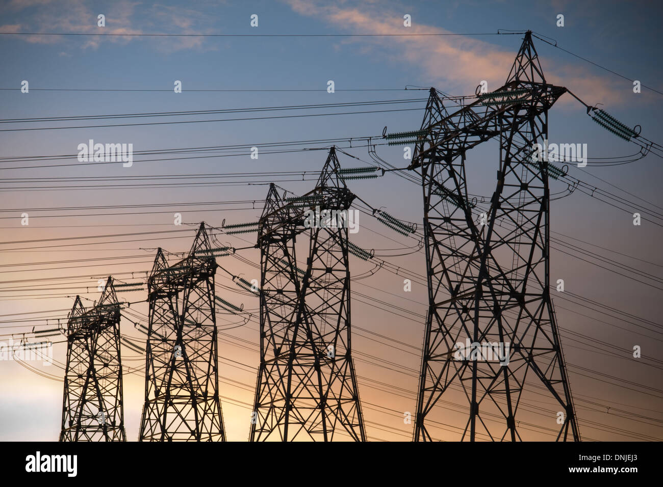 high voltage pylons silhouette cloudy sky background Stock Photo - Alamy