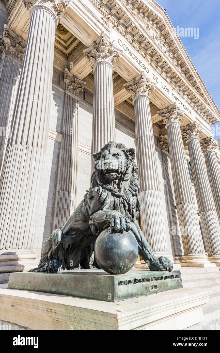 View of bronze lion statue at the pillared entrance of the iconic Congreso de Los Diputados (Congress of Deputies), Plaza de Las Cortes, Madrid, Spain Stock Photo