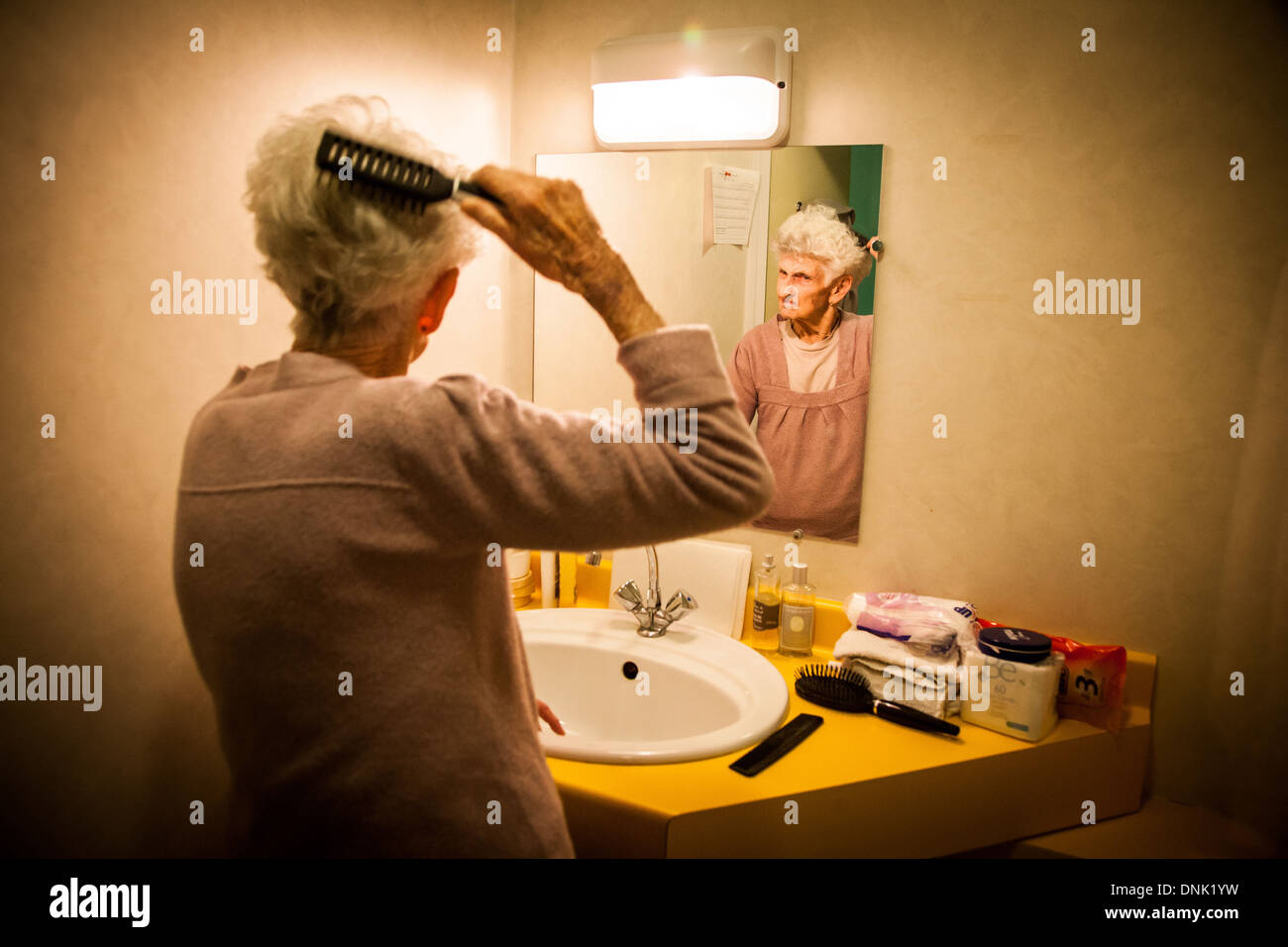 Senior woman brushing hair in mirror hi-res stock photography and images -  Alamy