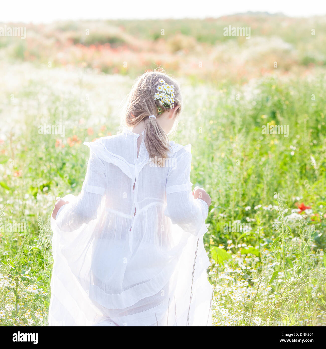 LITTLE GIRL WEARING A WHITE DRESS IN A FIELD OF FLOWERS Stock Photo - Alamy