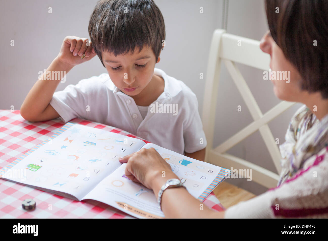 Mother helping a primary school pupil with homework Stock Photo