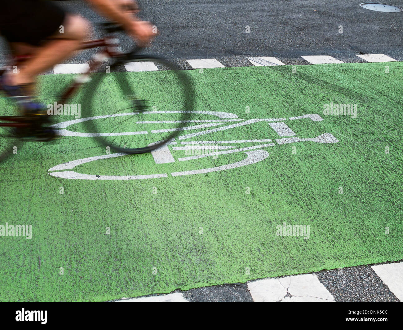 A lone cyclist rides their bike in a dedicated bike lane. Stock Photo