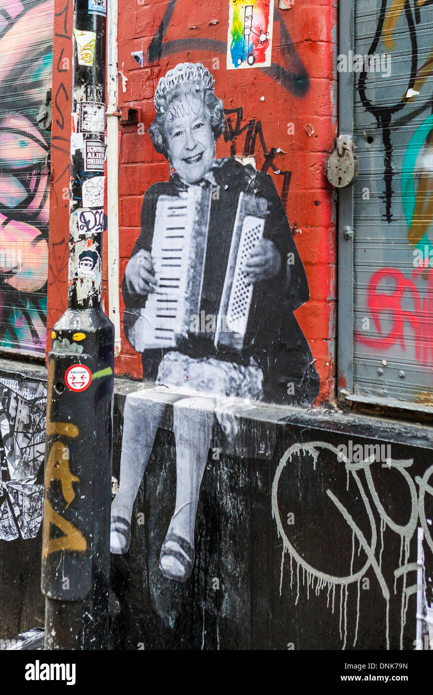Street artist art paste up - Queen Elizabeth ll playing an accordion - Grimsby street, off Brick lane, East London, UK Stock Photo