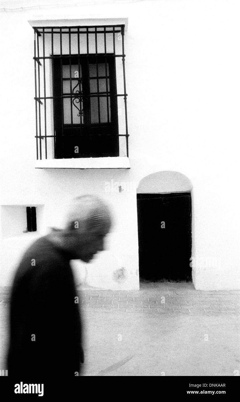 A man passes a home in the white village of Espera, Cadiz province, Andalucia, Spain, March 2005. Stock Photo